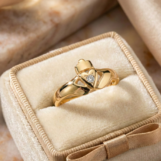 Gold cladadgh ring with a diamond in a jewelry box on a marble surface
