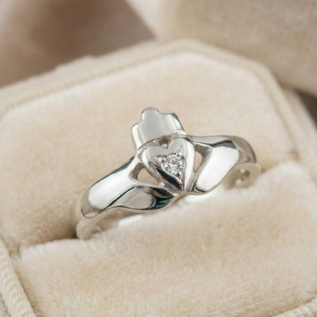 Silver claddgh ring with a heart design on a beige cushion