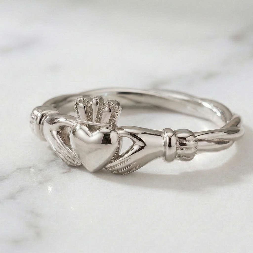 white gold Claddagh ring on a marble surface