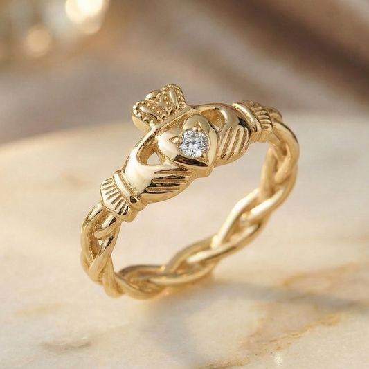 Gold claddagh ring with a diamond on a beige background