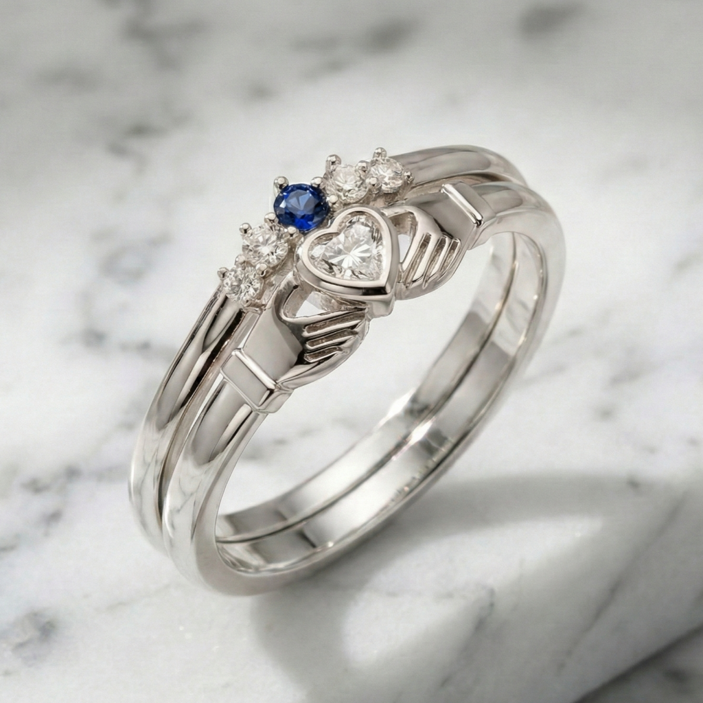 white gold claddagh ring with blue gemstone and heart-shaped diamond on a marble background