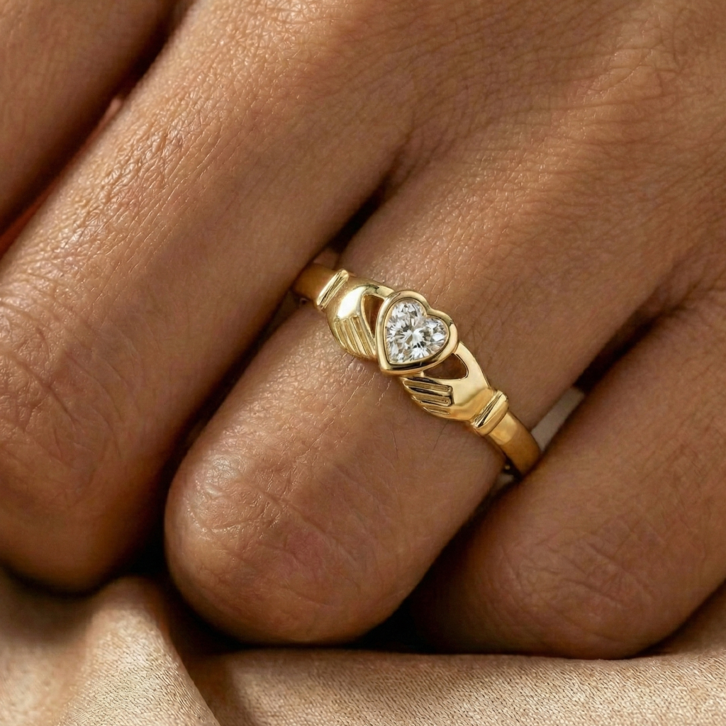 Gold ring with a heart-shaped diamond on a person's finger