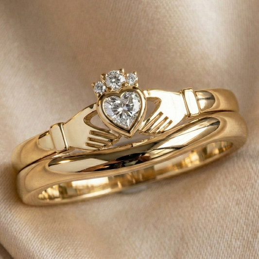 Gold claddagh ring with heart-shaped diamond and hand design on beige fabric
