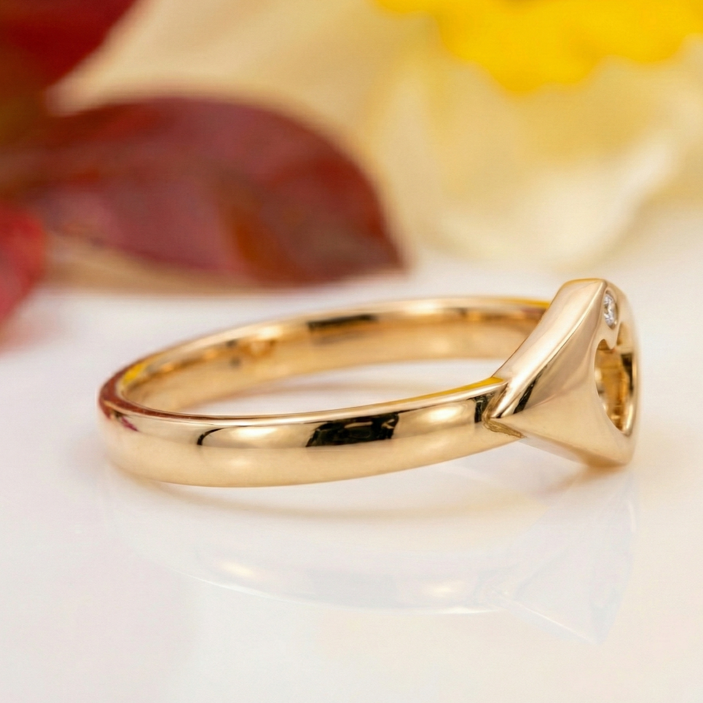 modern Claddagh ring with a diamond on a white surface with flowers in the background