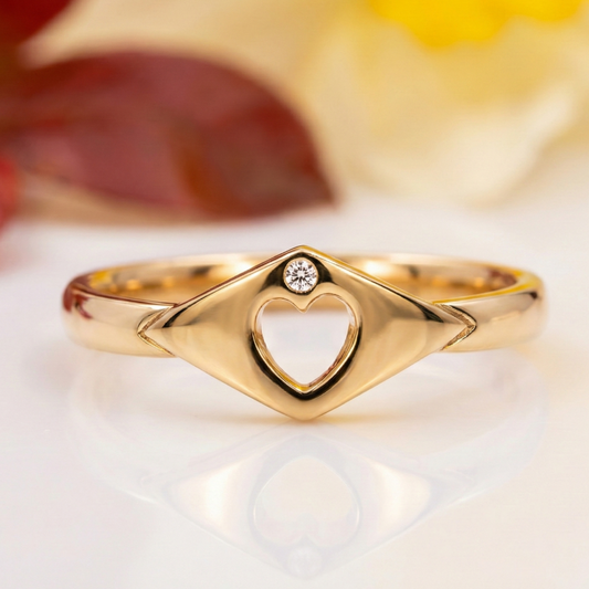 Gold ring with heart design and diamond on a soft background