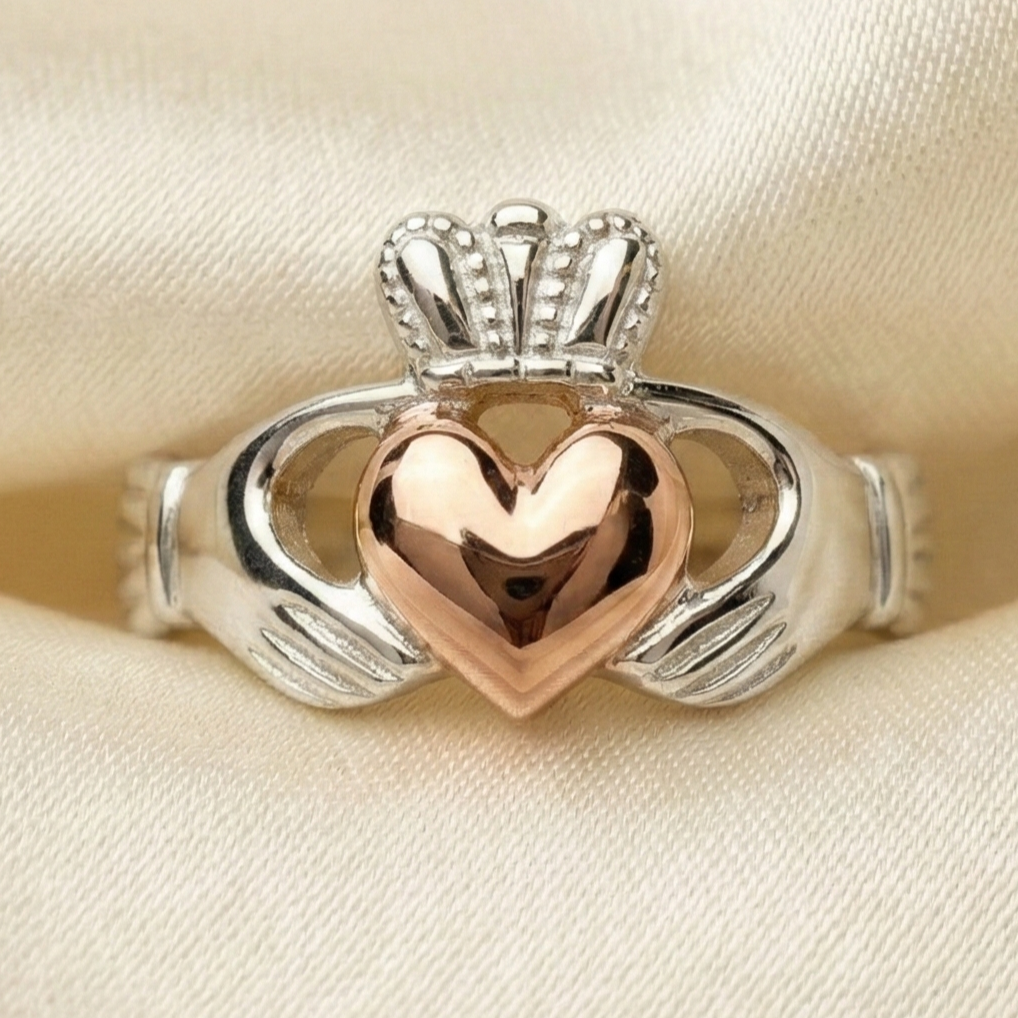 claddagh ring with a rose gold heart on a beige fabric background